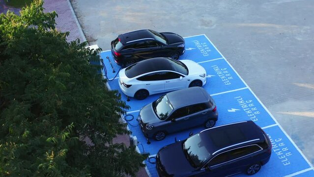 Electric vehicles charging at car supercharger station. Aerial view.