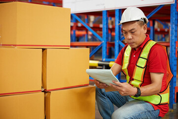 factory worker or warehouser checking corrugated boxes in the warehouse storage