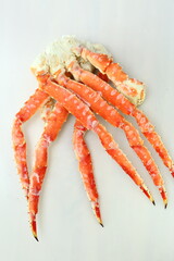 frosted Alaska king crab legs closeup photo on white table background