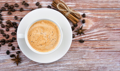 A cup of aromatic coffee and coffee beans on the wooden table. Close-up. Top view. Copy space. Selective focus.
