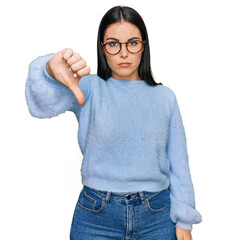 Young hispanic woman wearing casual clothes and glasses looking unhappy and angry showing rejection...