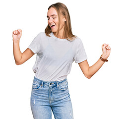 Fototapeta na wymiar Beautiful young blonde woman wearing casual white t shirt dancing happy and cheerful, smiling moving casual and confident listening to music