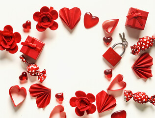 Valentine's day frame made with red hearts, flowers and candies on white background, top view