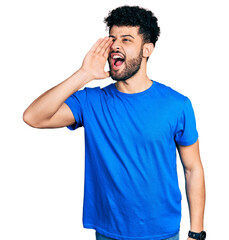 Young arab man with beard wearing casual blue t shirt shouting and screaming loud to side with hand on mouth. communication concept.