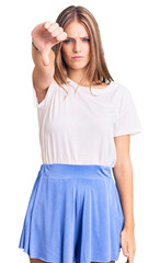 Young beautiful blonde woman wearing summer style looking unhappy and angry showing rejection and negative with thumbs down gesture. bad expression.