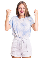 Young beautiful blonde woman wearing tye die tshirt screaming proud, celebrating victory and...