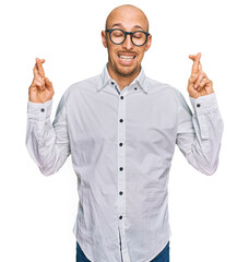 Bald man with beard wearing business shirt and glasses gesturing finger crossed smiling with hope and eyes closed. luck and superstitious concept.