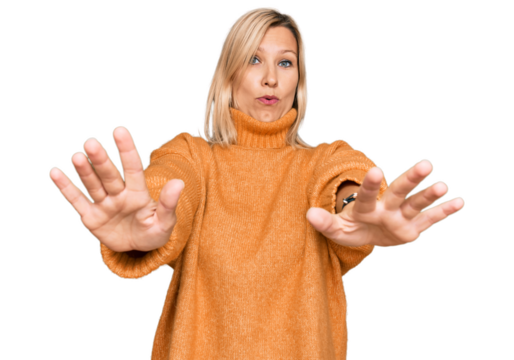 Middle age caucasian woman wearing casual winter sweater doing stop gesture with hands palms, angry and frustration expression