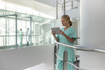 Healthcare professional in a modern hospital looking at results on a digital tablet