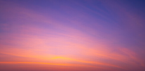 Sunset sky background with beautiful pink sunrise clouds on colorful dramatic twilight sky in...