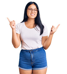 Young beautiful asian girl wearing casual clothes and glasses smiling confident pointing with fingers to different directions. copy space for advertisement