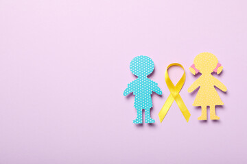 Paper figures of children with a yellow ribbon