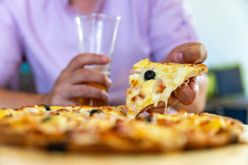 pizza au fromages avec olives dans la main d'un homme