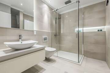 Fototapeta na wymiar Spacious bathroom in white Design with heated floors, walk-in shower, sink vanity and skylights.