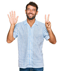 Naklejka premium Handsome young man with beard wearing casual fresh shirt showing and pointing up with fingers number seven while smiling confident and happy.