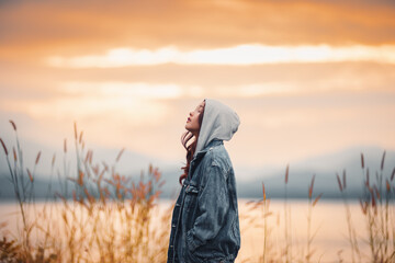 Woman with sunset light reflecting on water