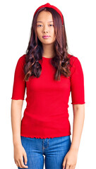 Young beautiful chinese girl wearing casual clothes and diadem with serious expression on face. simple and natural looking at the camera.