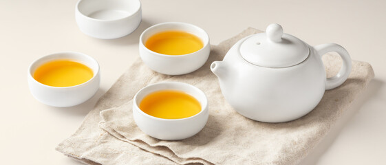 Tea set with teapot on linen cloth on beige background