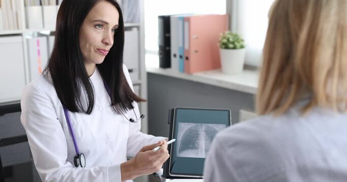 Woman doctor shows patient x-ray of lungs on tablet. Chronic obstructive pulmonary disease symptoms concept