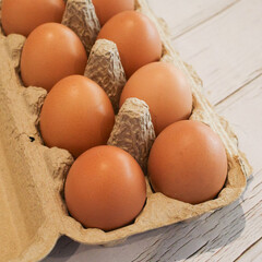 Fresh eggs in a cardboard egg tray.