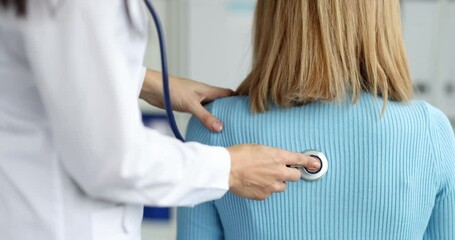 Doctor therapist listens with a stethoscope to patient breathing, rear view. General rules for auscultation concept