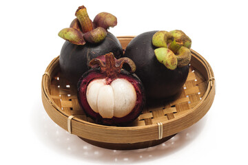 Half cut sliced and two whole fresh organic mangosteen delicious fruit in a bamboo basket plate isolated on white background clipping path
