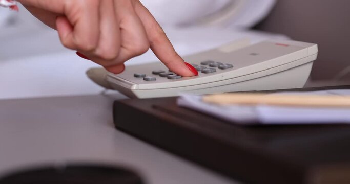 Hotel guest picks up phone and dials number for room service. Hotel phone services and call staff concept