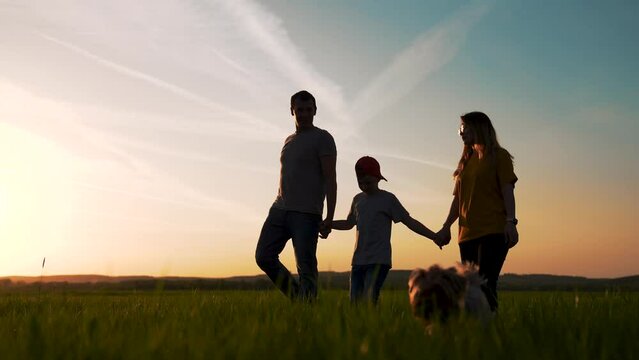 Happy family concept.family and dog walk together at sunset along forest field. a weekend walk together in nature. a child's dream. happy family on vacation with a dog. silhouette of family in nature