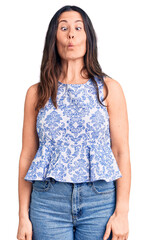 Obraz premium Young beautiful brunette woman wearing casual t-shirt making fish face with lips, crazy and comical gesture. funny expression.