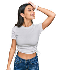 Obraz premium Young hispanic girl wearing casual white t shirt smiling confident touching hair with hand up gesture, posing attractive and fashionable
