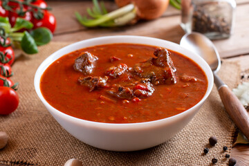 Beef goulash, soup and a stew, made of beef chuck steak and plenty of paprika on table. Hungarian traditional meal.