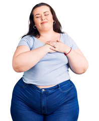 Young plus size woman wearing casual clothes smiling with hands on chest with closed eyes and...