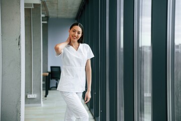Fototapeta na wymiar In the hall. Female doctor in white coat is indoors