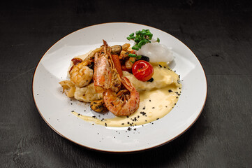 A dish of boiled shrimps with mashed potatoes, greens and vegetables
