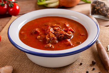 Beef goulash, soup and a stew, made of beef chuck steak and plenty of paprika on table. Hungarian traditional meal.