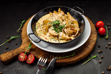 A dish of baked potatoes in the peasant style with bacon and sauce