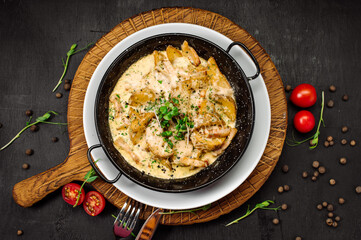 A dish of baked potatoes in the peasant style with bacon and sauce