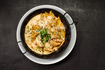 A dish of baked potatoes in the peasant style with bacon and sauce