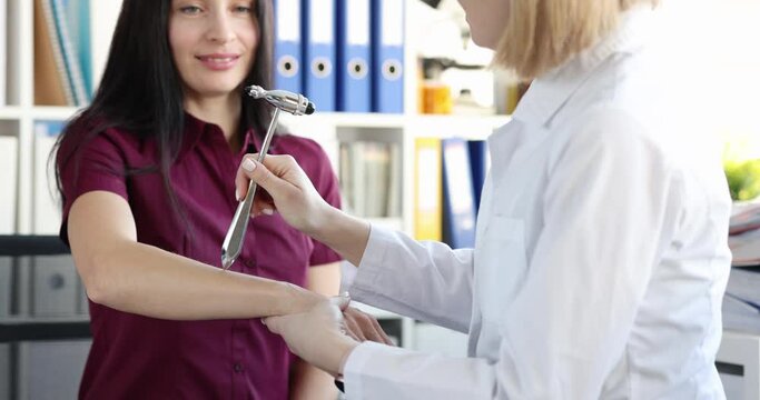 Neurologist checks patient's hand reflex in clinic. Pathological hand reflexes and methods of neurological examination