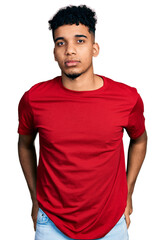 Young african american man wearing casual red t shirt relaxed with serious expression on face. simple and natural looking at the camera.