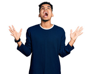 Young african american man wearing casual clothes crazy and mad shouting and yelling with aggressive expression and arms raised. frustration concept.