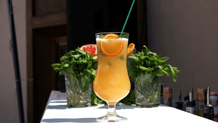 Close up of refreshing orange drink with mint leaf and ice, perfect for summer vacation at poolside. Enjoy healthy and fruity beverage at luxury resort spa.
