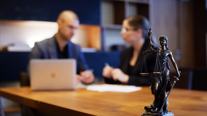 A lawyer meets with a new client. A young male lawyer in a suit sits at an office desk, shares legal advice, explains the inheritance process, tries to help. Legal advice concept