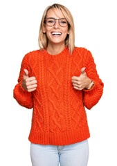 Obraz premium Beautiful blonde woman wearing casual clothes and glasses success sign doing positive gesture with hand, thumbs up smiling and happy. cheerful expression and winner gesture.