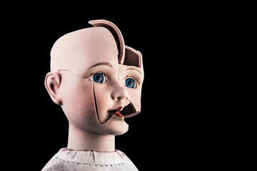Broken vintage doll head isolated on black background with clipping path
