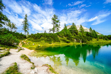 Fairy tale lake on the high plateau of the Tauplitzalm. View of the lake at the Totes Gebirge in Styria. Idyllic landscape with mountains and a lake on the Tauplitz.
