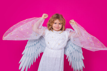 Child angel. Portrait of cute kid with angel wings isolated on pink studio background. Little...