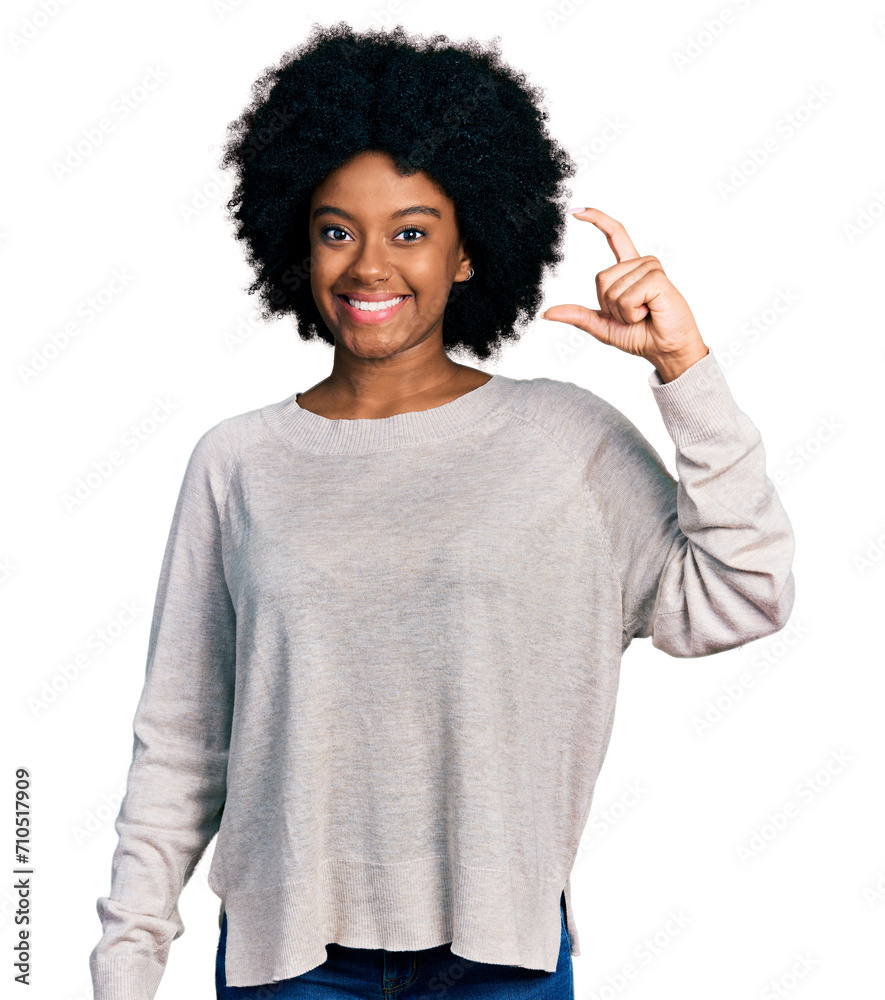 Wall mural Young african american woman wearing casual clothes smiling and confident gesturing with hand doing small size sign with fingers looking and the camera. measure concept.