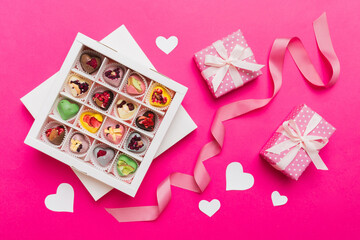 Valentine day composition: sweet candy, with gift boxes with bow and red felt hearts, photo template, background. Top View with copy space