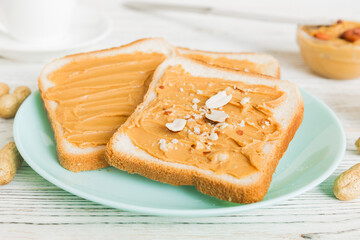 Peanut butter sandwiches or toasts on light table background.Breakfast. Vegetarian food. American cuisine top view vith copy space